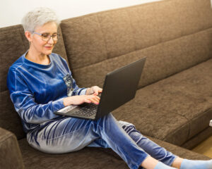 Frau auf der Couch mit Laptop